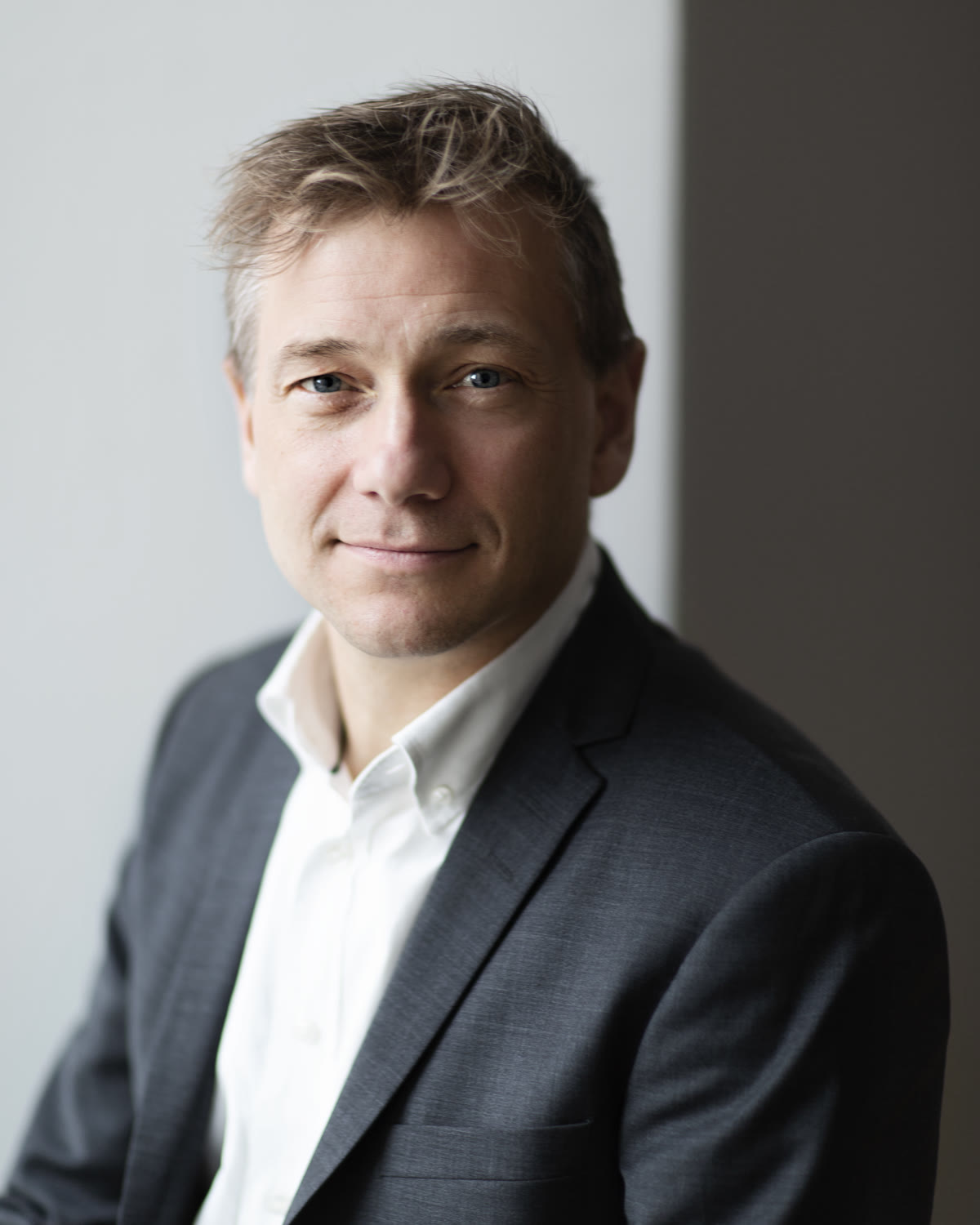Portræt af Thomas Terney i jakkesæt foran en lys væg